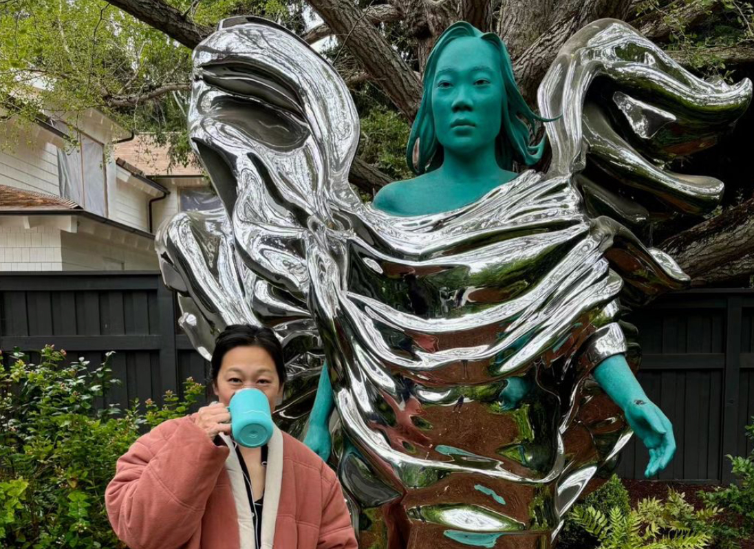 Mark Zuckerberg's wife Priscilla Chan stands next to a sculpture, made in her likeness, by the artist Daniel Arsham.